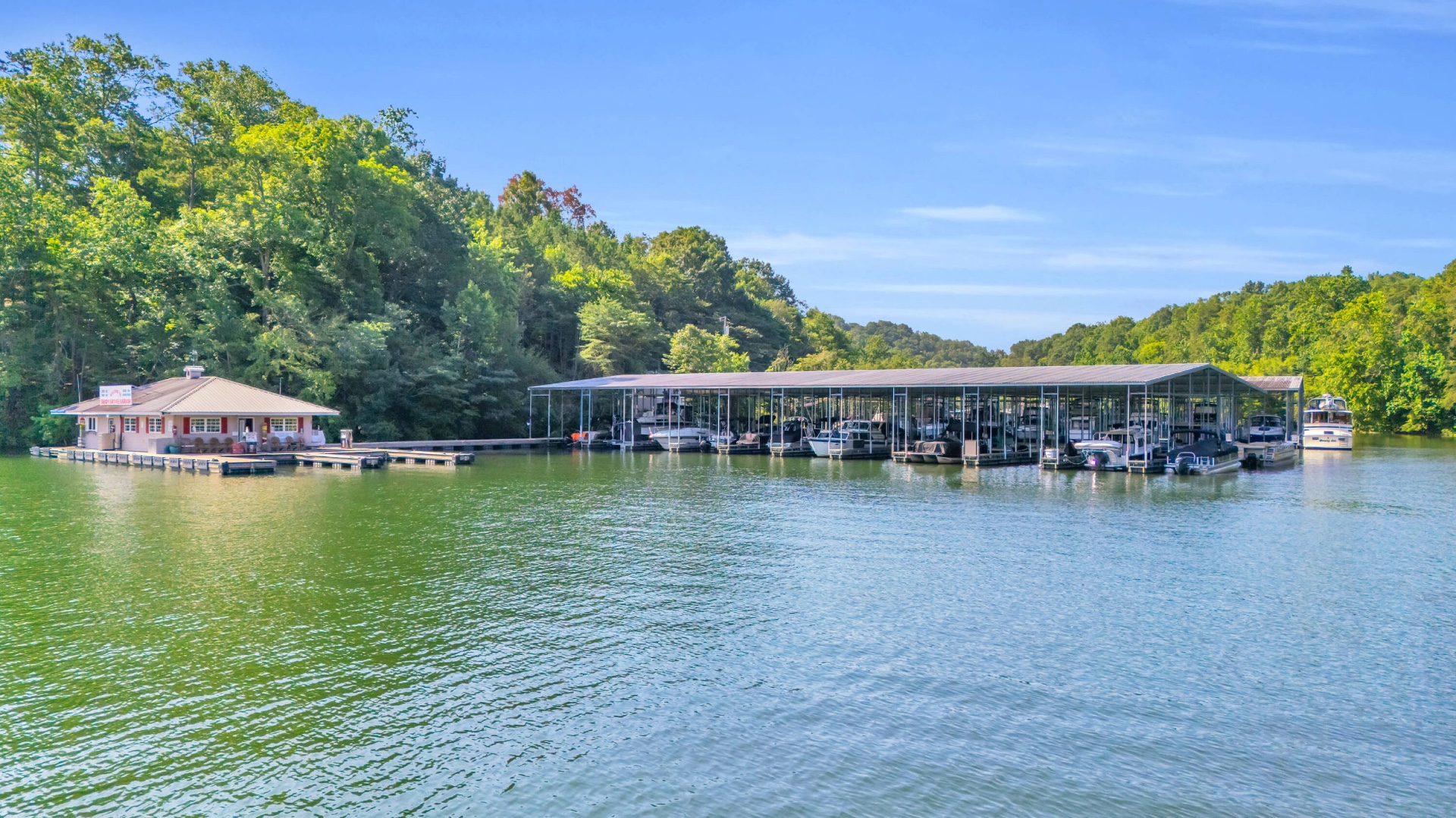 Shady Grove Harbor Marina from the water — covered slips and the floating store building along a wooded Tennessee shoreline.
