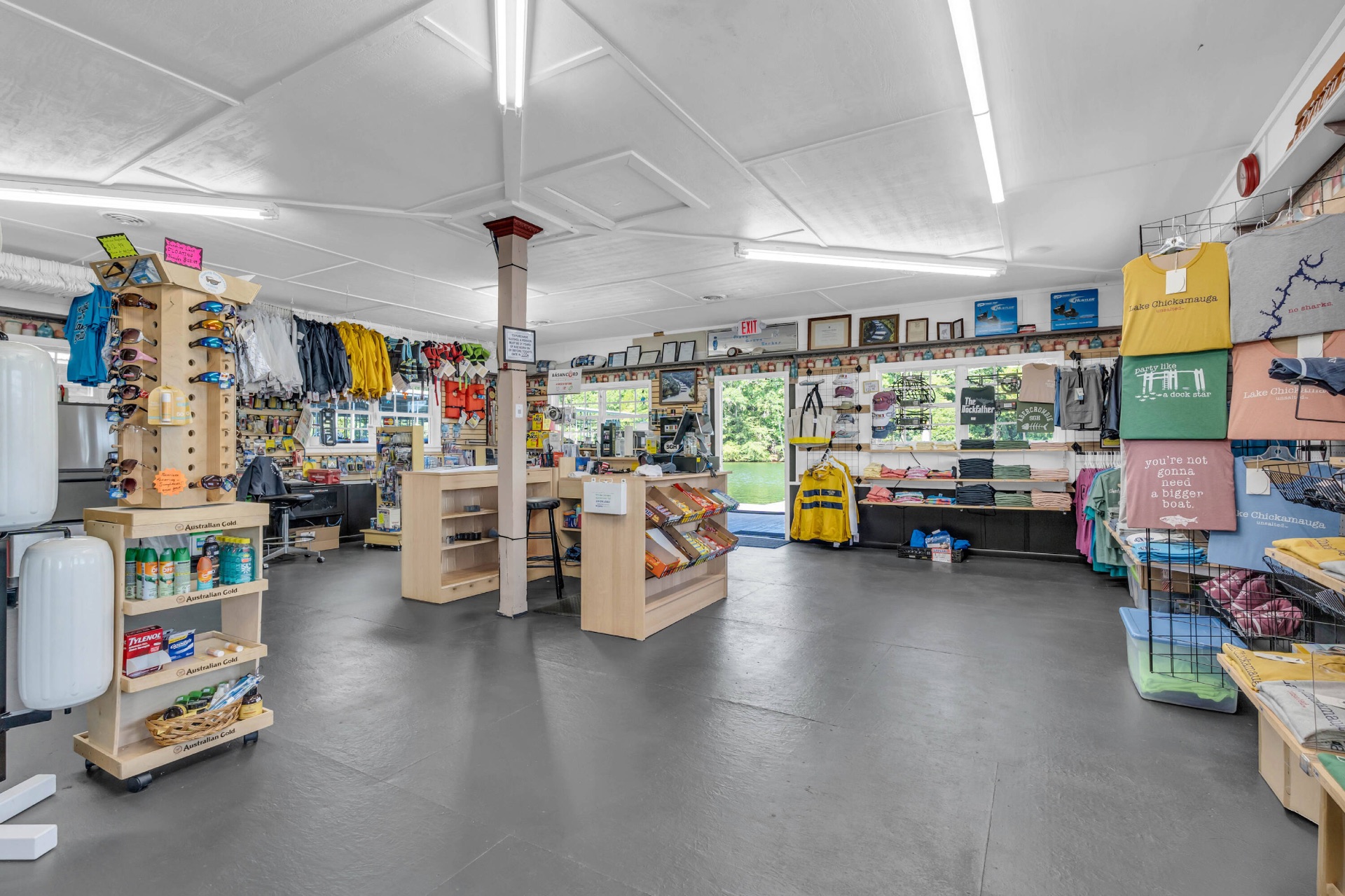 Inside the Shady Grove Harbor marina store — apparel, sunglasses, life jackets, snacks, and boating supplies with a lake view.