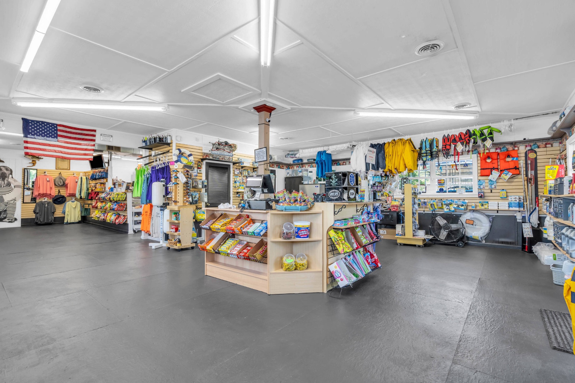 Wide interior view of the marina store showing candy, snacks, drinks, apparel, and safety gear.
